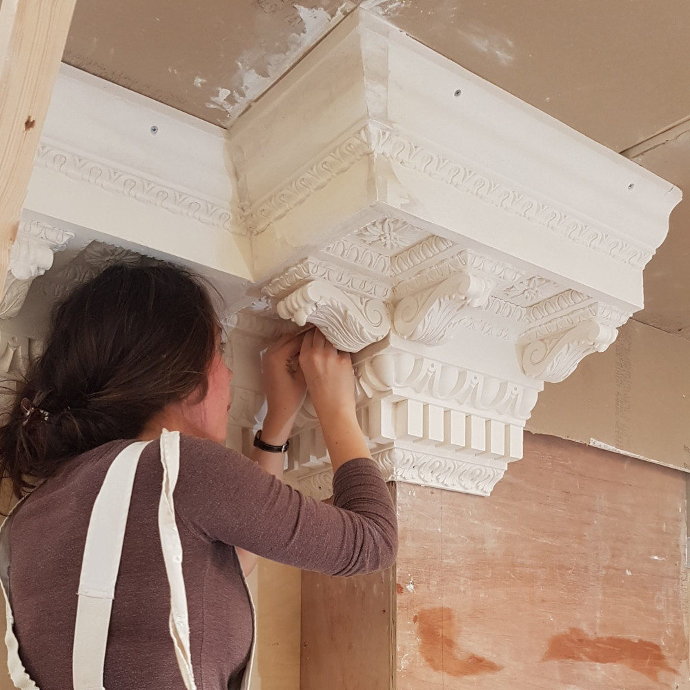 Woman creating decorative plaster work